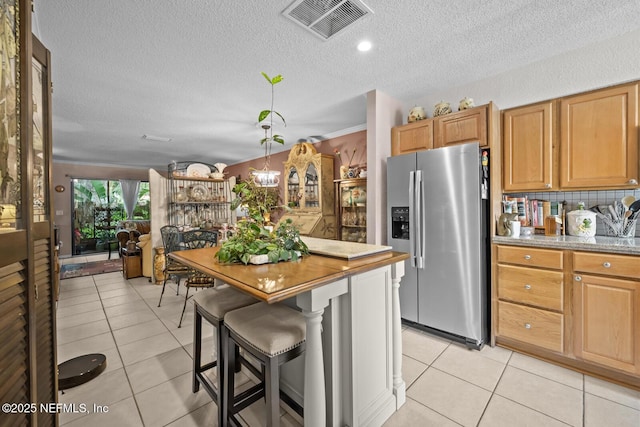 5811 Atlantic Blvd Unit 25, Jacksonville, FL 32207 - kitchen with stainless steel fridge, a textured ceiling, light tile patterned floors, a chandelier, and decorative backsplash