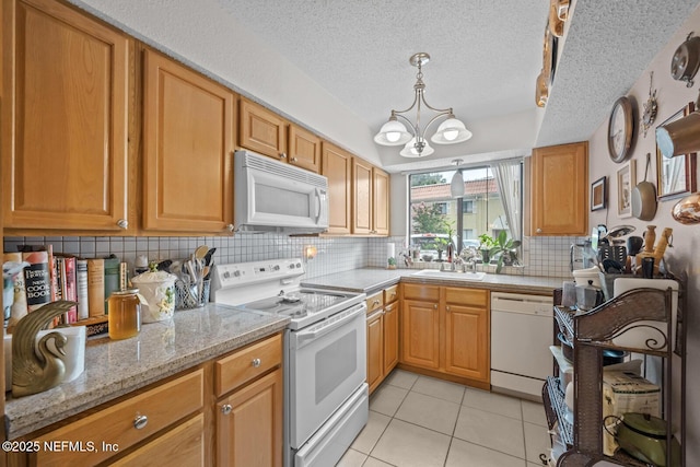 5811 Atlantic Blvd Unit 25, Jacksonville, FL 32207 - kitchen featuring white appliances, backsplash, a chandelier, light tile patterned floors, and light stone counters