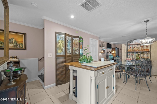 5811 Atlantic Blvd Unit 25, Jacksonville, FL 32207 - kitchen with light tile patterned floors, white cabinetry, a chandelier, a textured ceiling, and a center island
