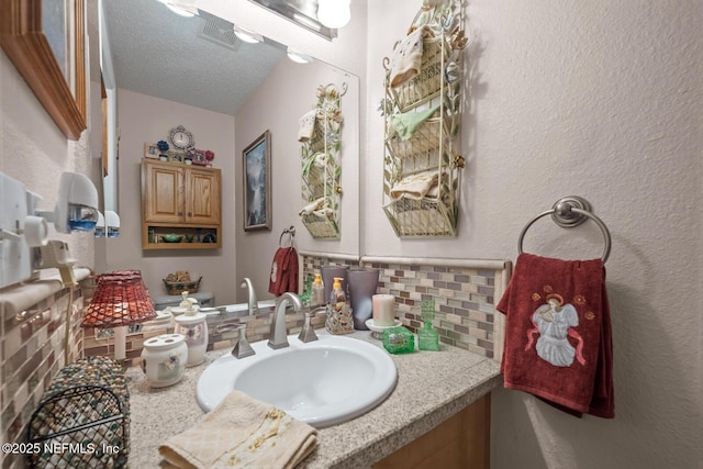 5811 Atlantic Blvd Unit 25, Jacksonville, FL 32207 - bathroom with decorative backsplash, vanity, a textured ceiling, and a textured wall