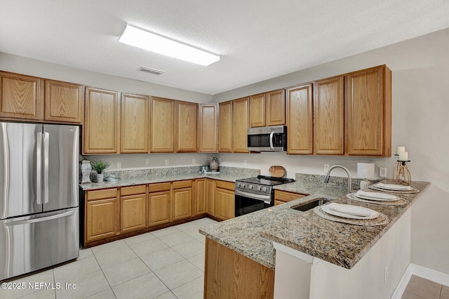 3164 Ravines Rd, Middleburg, FL 32068 - kitchen featuring stainless steel appliances, a peninsula, light stone counters, and light tile patterned flooring