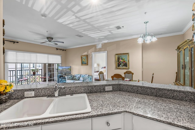 160 Legendary Dr Unit 204, Saint Augustine, FL 32092 - kitchen with open floor plan, a ceiling fan, white cabinets, hanging light fixtures, and crown molding