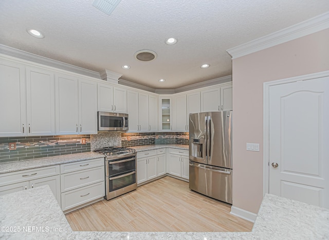 1356 Barrington Cir, Saint Augustine, FL 32092 - kitchen with stainless steel appliances, ornamental molding, glass insert cabinets, decorative backsplash, and a textured ceiling