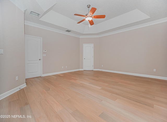 1356 Barrington Cir, Saint Augustine, FL 32092 - empty room featuring ceiling fan, light wood finished floors, a tray ceiling, a textured ceiling, and ornamental molding