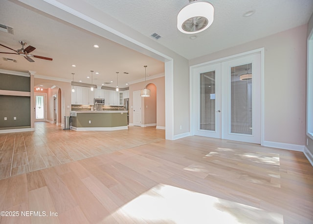 1356 Barrington Cir, Saint Augustine, FL 32092 - unfurnished living room featuring arched walkways, french doors, ceiling fan, light wood-type flooring, and recessed lighting