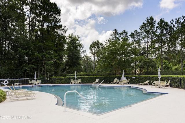 1356 Barrington Cir, Saint Augustine, FL 32092 - community pool featuring a patio and view of wooded area
