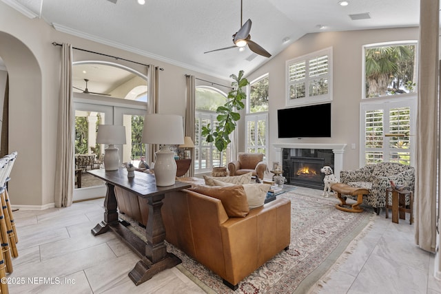 312 Bartram Trl, Saint Johns, FL 32259 - living area featuring a ceiling fan, arched walkways, a glass covered fireplace, vaulted ceiling, and ornamental molding