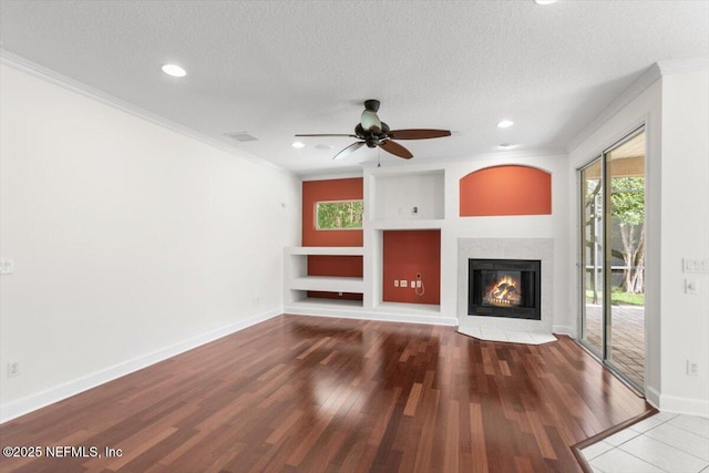336 Edge Of Woods Rd, Saint Augustine, FL 32092 - unfurnished living room featuring a fireplace with flush hearth, crown molding, wood finished floors, ceiling fan, and a textured ceiling