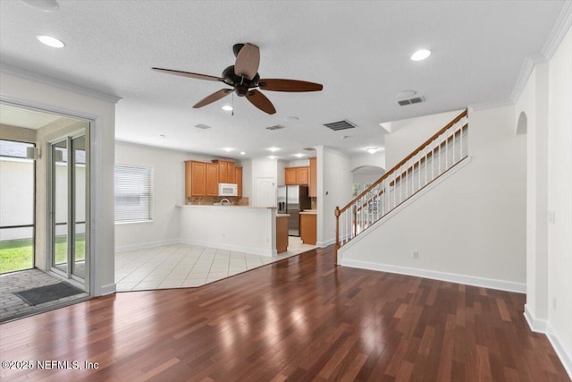 336 Edge Of Woods Rd, Saint Augustine, FL 32092 - unfurnished living room featuring wood finished floors, ceiling fan, stairway, ornamental molding, and arched walkways