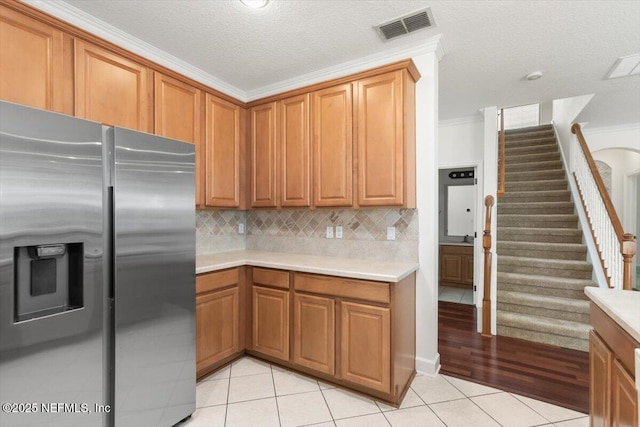 336 Edge Of Woods Rd, Saint Augustine, FL 32092 - kitchen with stainless steel fridge with ice dispenser, light tile patterned floors, light countertops, ornamental molding, and backsplash