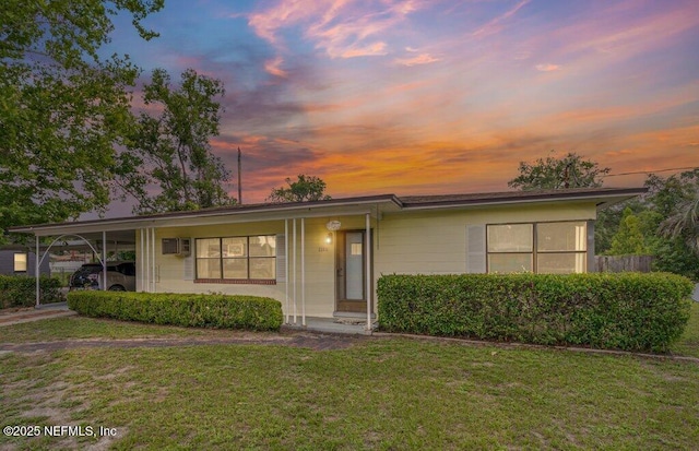 2305 Broward Rd, Jacksonville, FL 32218 - ranch-style house featuring a lawn, an attached carport, and an AC wall unit