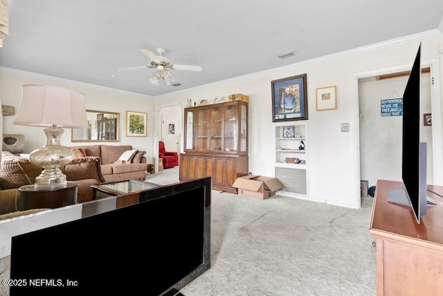 2305 Broward Rd, Jacksonville, FL 32218 - carpeted living area featuring a ceiling fan, crown molding, built in shelves, and arched walkways