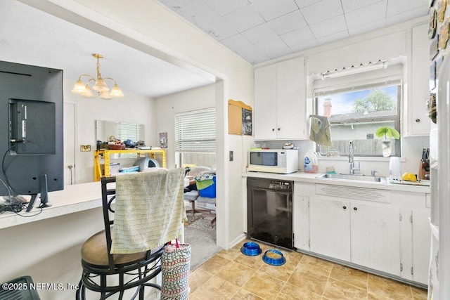 2305 Broward Rd, Jacksonville, FL 32218 - kitchen featuring dishwasher, white microwave, light countertops, a chandelier, and white cabinetry