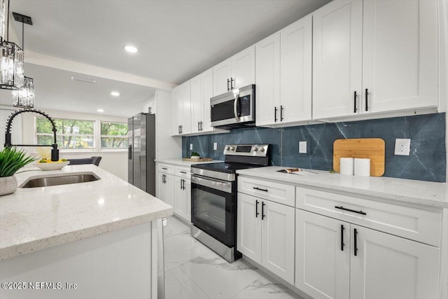 8940 Monroe Ave, Jacksonville, FL 32208 - kitchen with stainless steel appliances, white cabinets, recessed lighting, tasteful backsplash, and light marble finish flooring