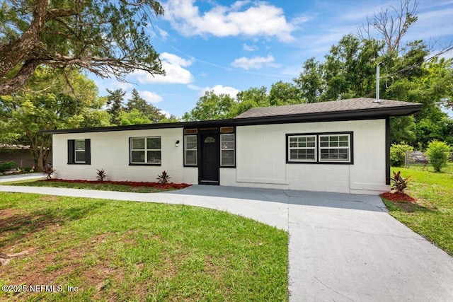 8940 Monroe Ave, Jacksonville, FL 32208 - ranch-style home featuring concrete block siding, a front lawn, and driveway