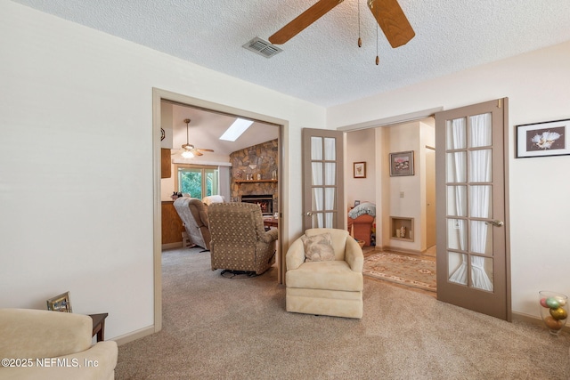 835 Fountain Dr, Fernandina Beach, FL 32034 - living area with ceiling fan, carpet, a stone fireplace, and a textured ceiling