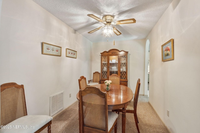 835 Fountain Dr, Fernandina Beach, FL 32034 - dining space with light carpet, arched walkways, a textured ceiling, and ceiling fan