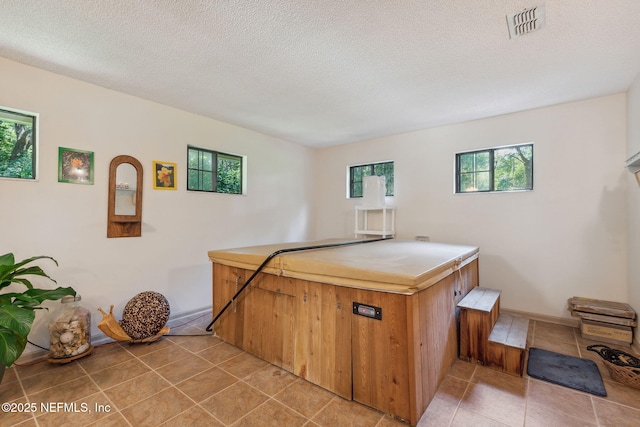 835 Fountain Dr, Fernandina Beach, FL 32034 - kitchen with plenty of natural light, light tile patterned floors, a textured ceiling, a peninsula, and light countertops