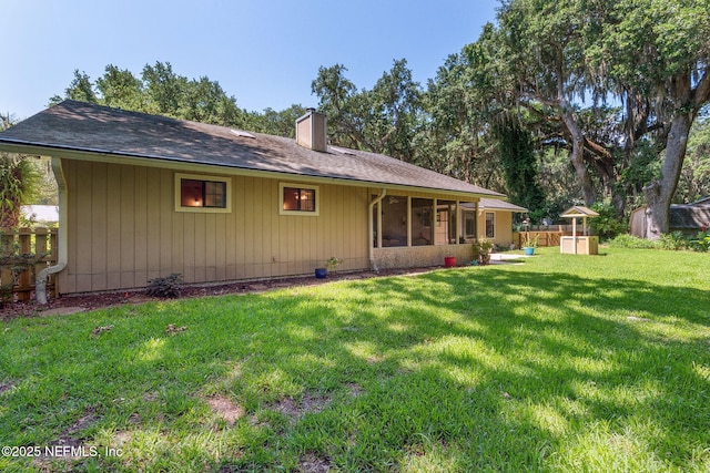 835 Fountain Dr, Fernandina Beach, FL 32034 - rear view of house featuring a chimney and a sunroom