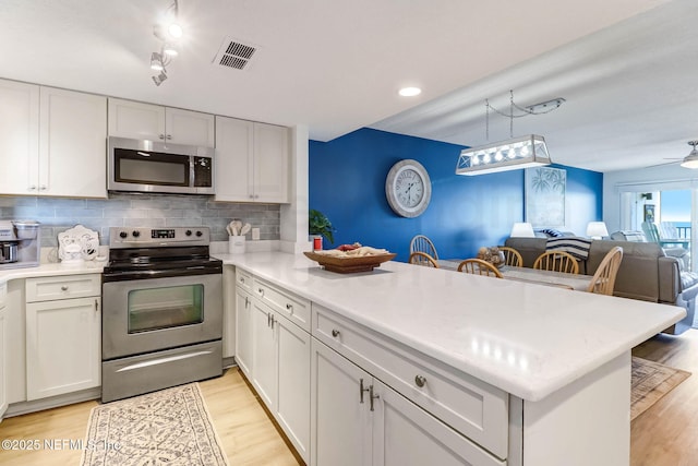 3350 S Fletcher Ave Unit C5, Fernandina Beach, FL 32034 - kitchen featuring appliances with stainless steel finishes, a peninsula, open floor plan, and light wood-style flooring