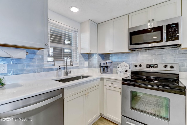 3350 S Fletcher Ave Unit C5, Fernandina Beach, FL 32034 - kitchen featuring stainless steel appliances, white cabinetry, light countertops, and backsplash