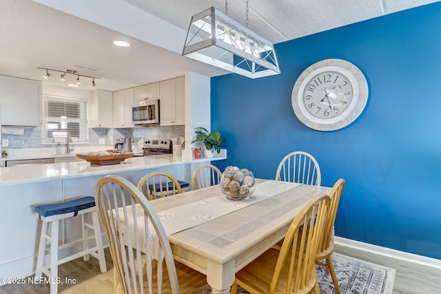 3350 S Fletcher Ave Unit C5, Fernandina Beach, FL 32034 - dining space featuring light wood finished floors, a textured ceiling, and rail lighting