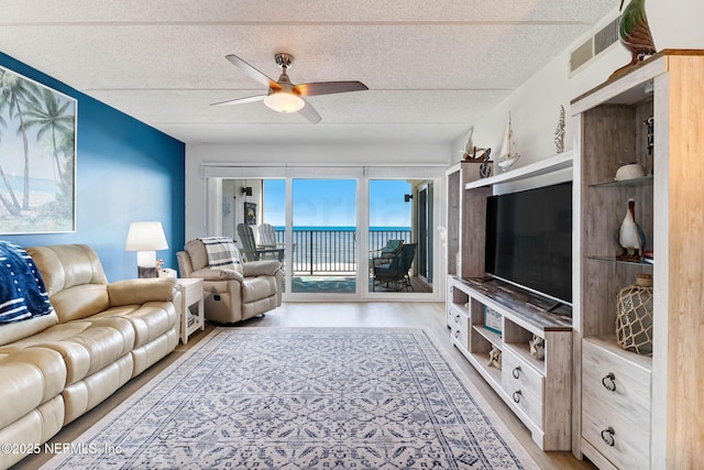 3350 S Fletcher Ave Unit C5, Fernandina Beach, FL 32034 - living room featuring light wood finished floors, ceiling fan, and a textured ceiling
