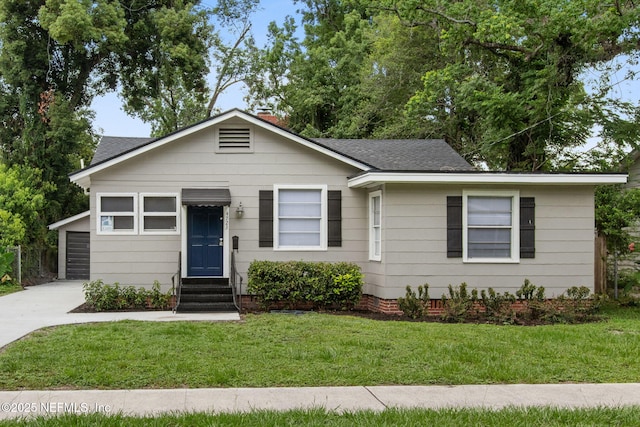 4723 Sunderland Rd, Jacksonville, FL 32210 - view of front of home featuring roof with shingles, a front yard, entry steps, a garage, and concrete driveway