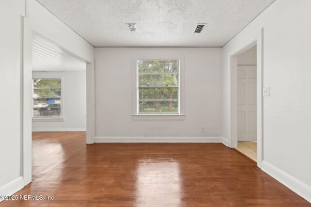 4723 Sunderland Rd, Jacksonville, FL 32210 - empty room featuring plenty of natural light, wood finished floors, and a textured ceiling