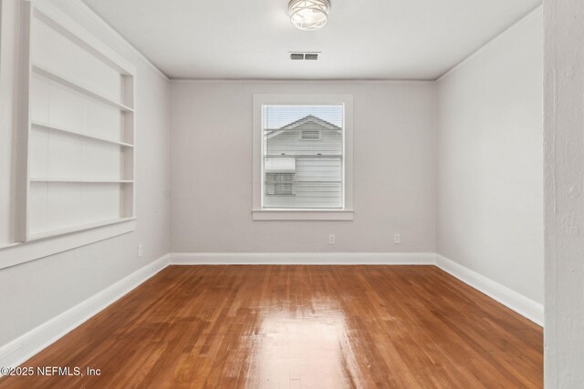 4723 Sunderland Rd, Jacksonville, FL 32210 - spare room featuring wood finished floors and built in features
