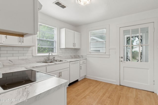 4723 Sunderland Rd, Jacksonville, FL 32210 - kitchen featuring white dishwasher, decorative backsplash, white cabinetry, light countertops, and light wood-style floors