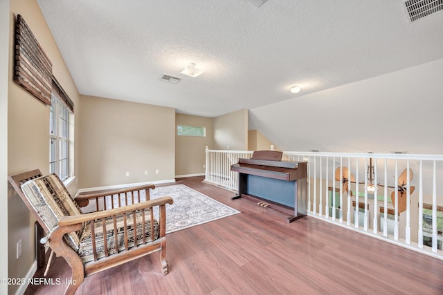 2502 Willow Creek Dr, Fleming Island, FL 32003 - living area featuring wood finished floors, plenty of natural light, an upstairs landing, and a textured ceiling
