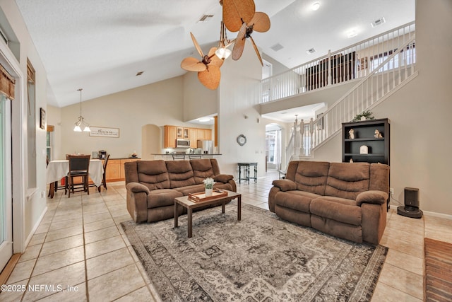 2502 Willow Creek Dr, Fleming Island, FL 32003 - living area with light tile patterned floors, arched walkways, high vaulted ceiling, plenty of natural light, and stairs