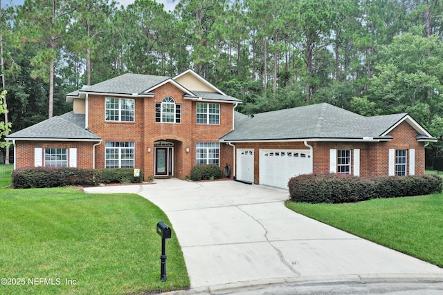 2502 Willow Creek Dr, Fleming Island, FL 32003 - colonial house featuring an attached garage, brick siding, concrete driveway, and a front lawn