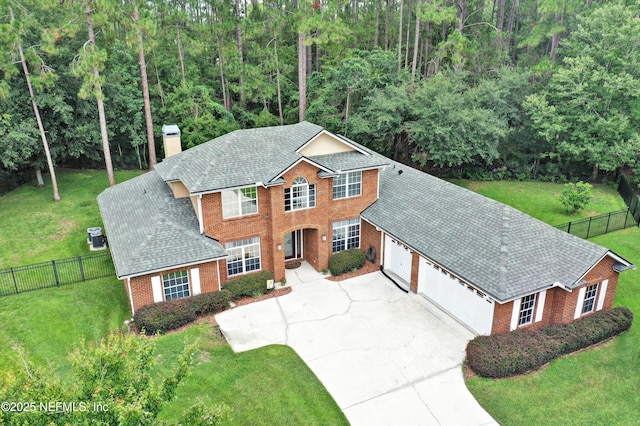 2502 Willow Creek Dr, Fleming Island, FL 32003 - colonial home with brick siding, a garage, a chimney, concrete driveway, and roof with shingles