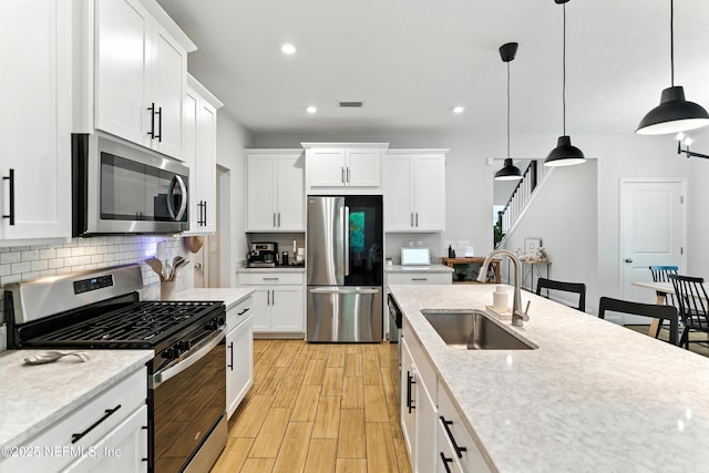133 Wambaw Dr, Saint Johns, FL 32259 - kitchen featuring appliances with stainless steel finishes, tasteful backsplash, light wood finished floors, recessed lighting, and pendant lighting