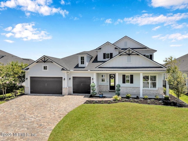 246 Glenneyre Cir, Saint Augustine, FL 32092 - modern farmhouse style home featuring board and batten siding, a front lawn, decorative driveway, covered porch, and a garage