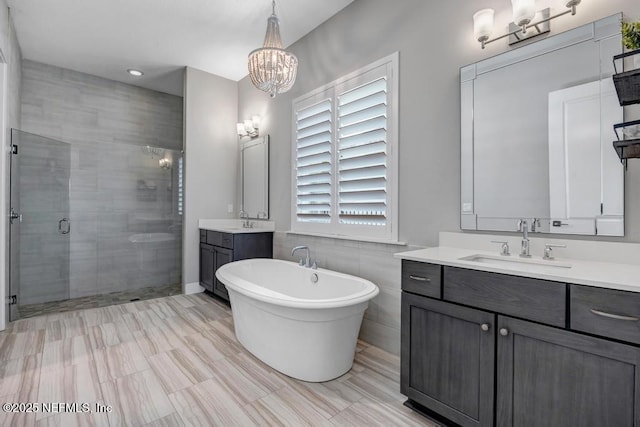 246 Glenneyre Cir, Saint Augustine, FL 32092 - full bath featuring a shower stall, two vanities, a freestanding bath, and a chandelier