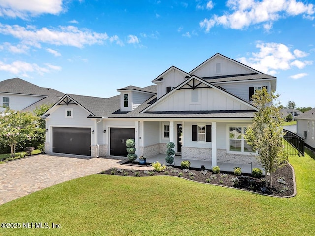 246 Glenneyre Cir, Saint Augustine, FL 32092 - modern farmhouse style home with board and batten siding, decorative driveway, a garage, stone siding, and a front yard