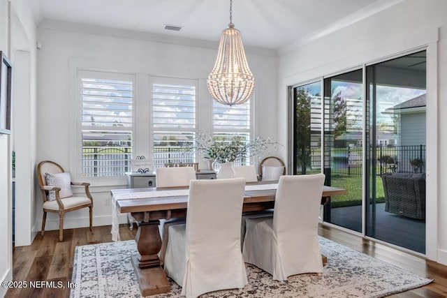 246 Glenneyre Cir, Saint Augustine, FL 32092 - dining area with a chandelier, wood finished floors, and ornamental molding