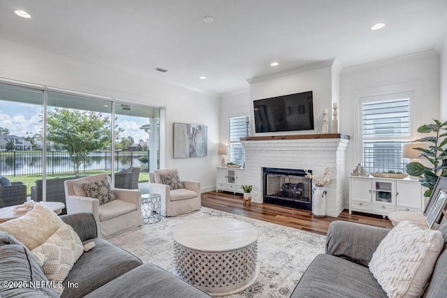 246 Glenneyre Cir, Saint Augustine, FL 32092 - living room with ornamental molding, wood finished floors, a water view, a brick fireplace, and recessed lighting