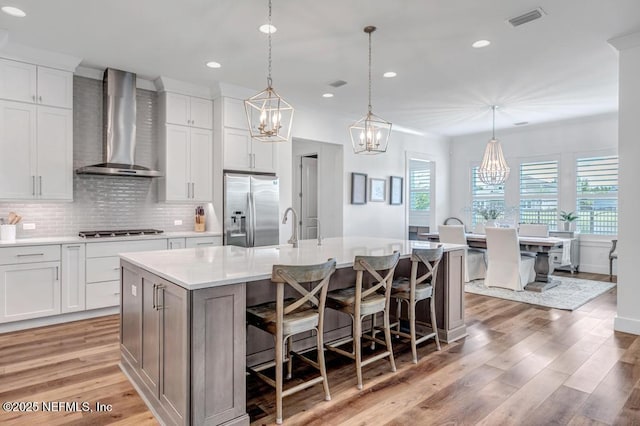 246 Glenneyre Cir, Saint Augustine, FL 32092 - kitchen featuring stainless steel fridge with ice dispenser, wall chimney range hood, a chandelier, plenty of natural light, and recessed lighting