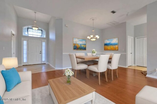 644 Casa Fuerta Ln, Saint Augustine, FL 32080 - living area with a chandelier, wood finished floors, and a towering ceiling