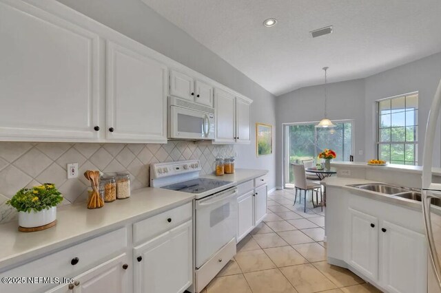644 Casa Fuerta Ln, Saint Augustine, FL 32080 - kitchen with white appliances, decorative backsplash, white cabinetry, lofted ceiling, and light countertops