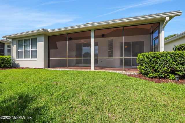 644 Casa Fuerta Ln, Saint Augustine, FL 32080 - rear view of property with a lawn, a sunroom, and stucco siding