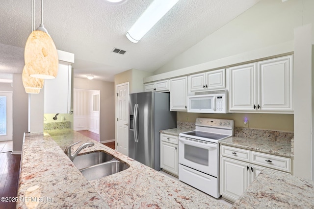 1835 Harbor Island Dr, Fleming Island, FL 32003 - kitchen with white appliances, a textured ceiling, vaulted ceiling, white cabinets, and light stone countertops