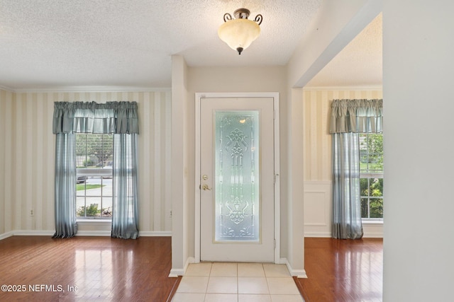1835 Harbor Island Dr, Fleming Island, FL 32003 - foyer entrance with a textured ceiling, wood finished floors, wallpapered walls, and crown molding