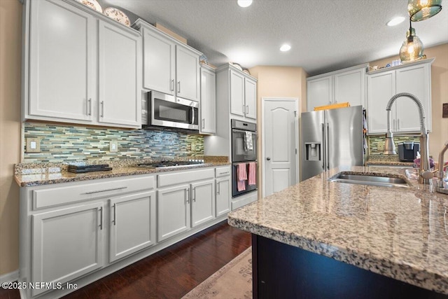 141 Mediterra Ave, Ponte Vedra, FL 32081 - kitchen featuring appliances with stainless steel finishes, dark wood finished floors, light stone countertops, tasteful backsplash, and recessed lighting