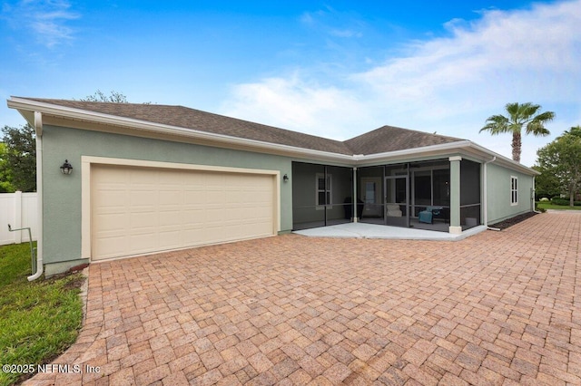 141 Mediterra Ave, Ponte Vedra, FL 32081 - view of front facade featuring a sunroom, stucco siding, decorative driveway, and a garage