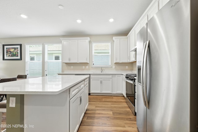 129 Oyster Shell Ter, Ponte Vedra, FL 32081 - kitchen with appliances with stainless steel finishes, a kitchen island, light countertops, recessed lighting, and white cabinets